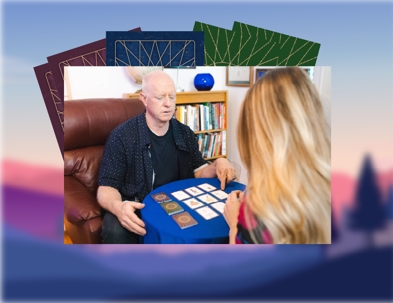 Bradley reading the cards with a client across a small table.